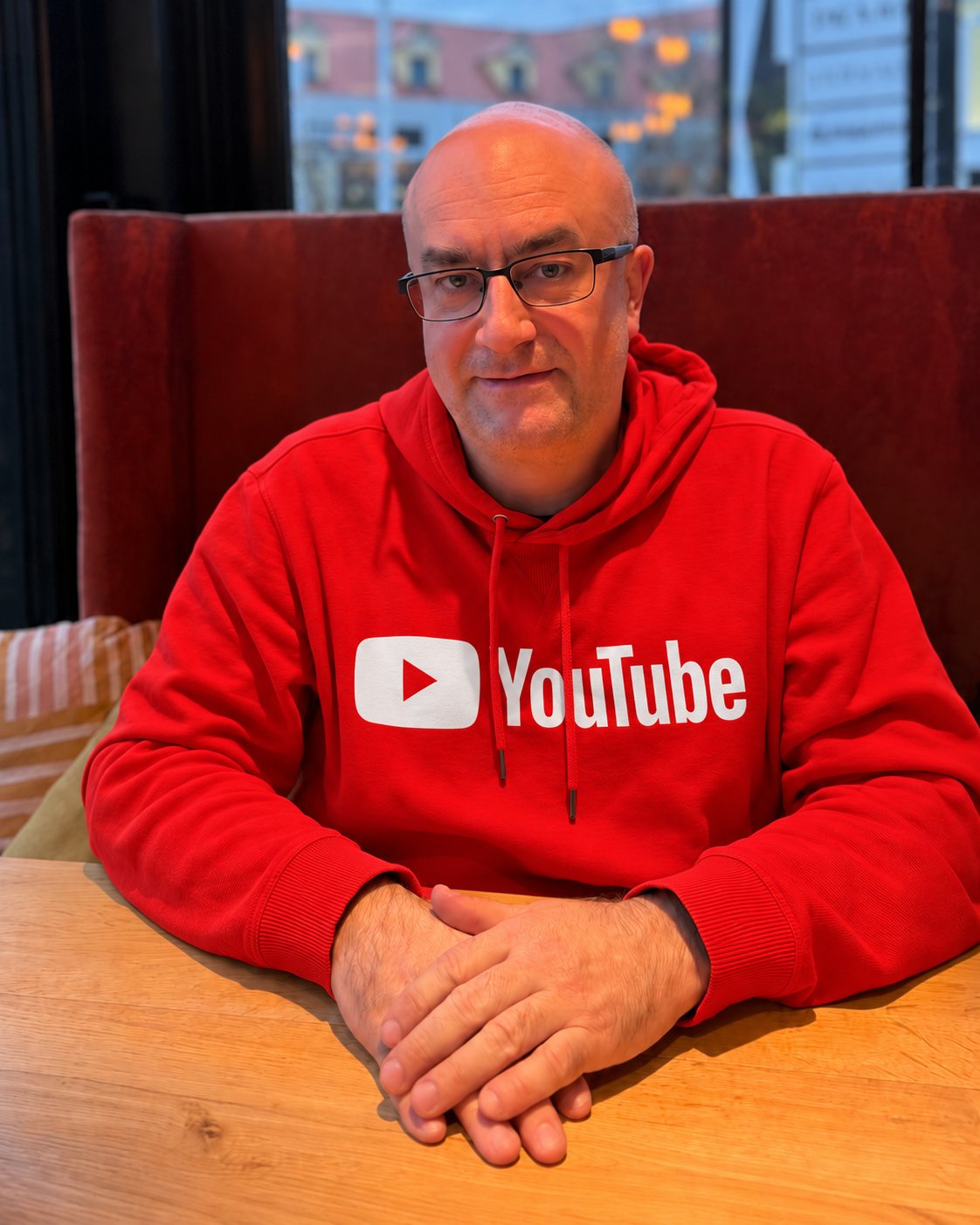 Portrait of a person wearing glasses and a red YouTube hoodie